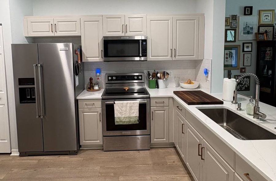 Finished kitchen with white cabinets, stainless appliances, subway tile backsplash and butcher-block counter by No Bull Man